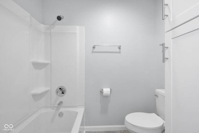 full bathroom featuring toilet, baseboards, and shower / washtub combination