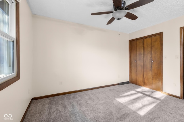 unfurnished bedroom with multiple windows, baseboards, a closet, and carpet floors