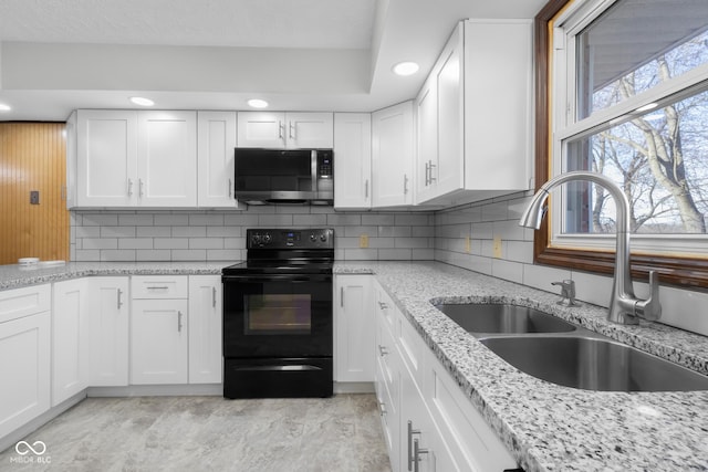 kitchen featuring stainless steel microwave, electric range, white cabinets, and a sink