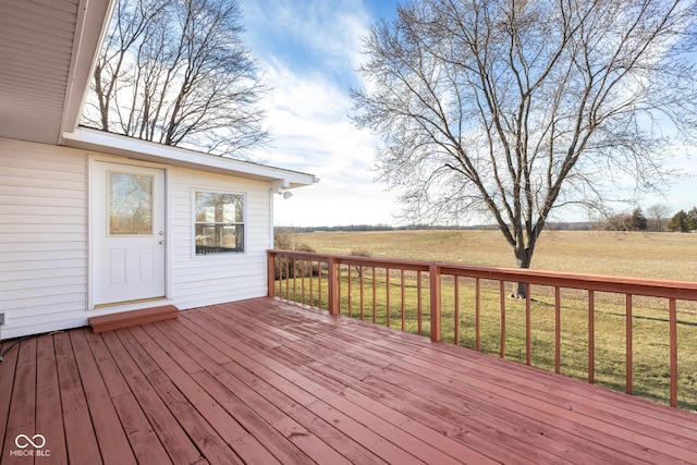 deck with a rural view and a yard