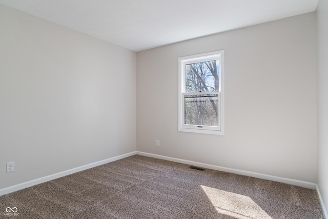 carpeted empty room featuring baseboards and visible vents