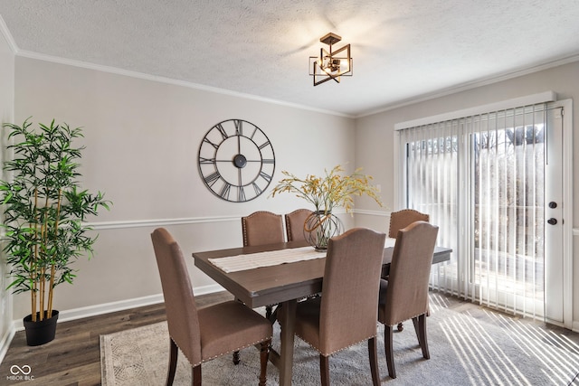 dining room featuring a textured ceiling, crown molding, baseboards, and wood finished floors