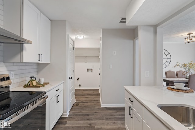 kitchen featuring decorative backsplash, electric range, dark wood-style flooring, and white cabinetry