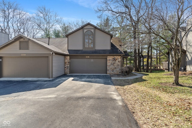 view of front of property with stone siding, driveway, and a shingled roof