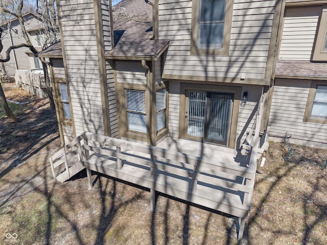 rear view of house featuring roof with shingles