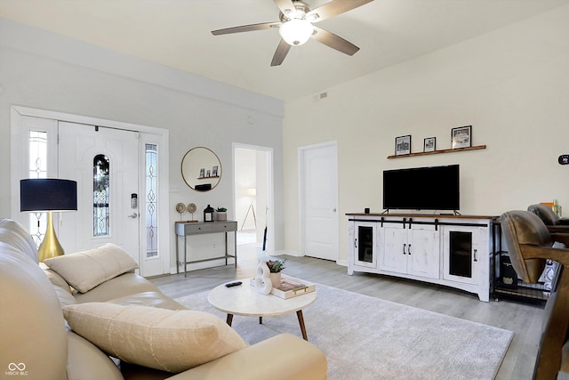 living room with visible vents, baseboards, a ceiling fan, and wood finished floors