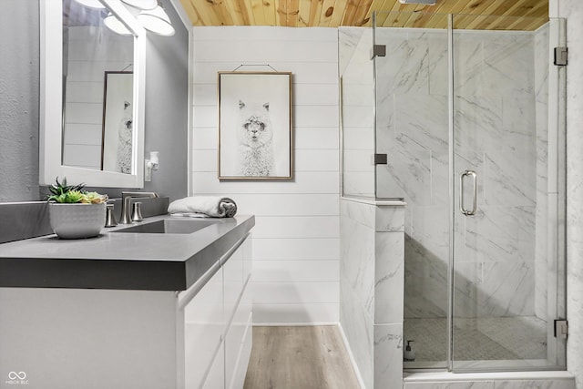 full bath with vanity, wooden ceiling, wood finished floors, and a marble finish shower