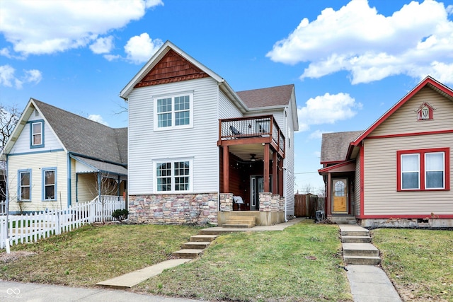 view of front facade featuring a front yard, fence, and stone siding