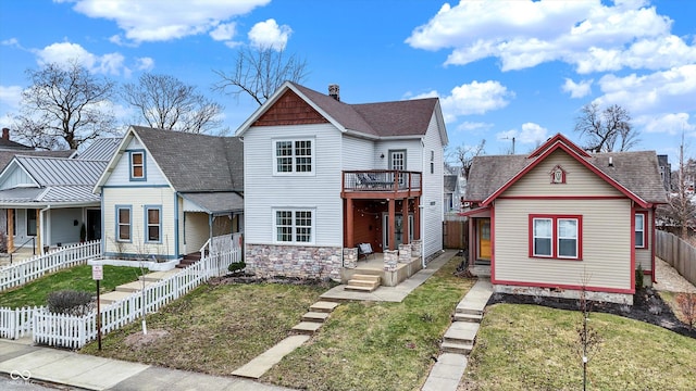 victorian-style house with a fenced backyard, a front yard, and a shingled roof