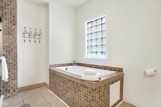 full bath featuring tile patterned flooring, baseboards, and a garden tub