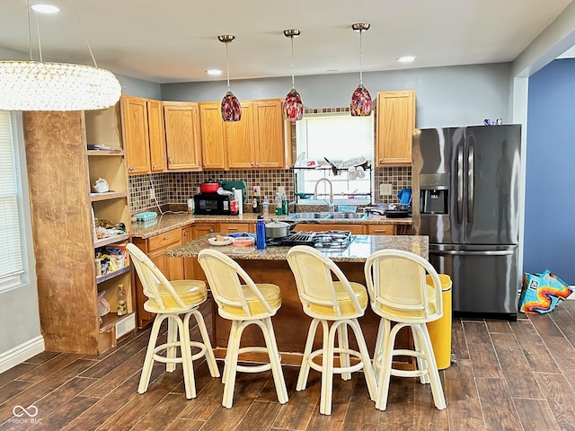 kitchen featuring backsplash, open shelves, wood finish floors, stainless steel fridge with ice dispenser, and a sink