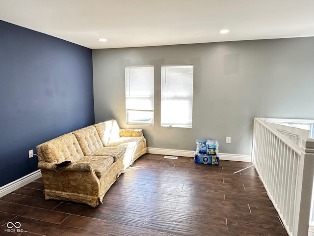 living area with recessed lighting, visible vents, baseboards, and wood finished floors