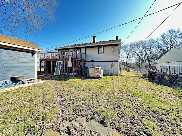 back of property featuring a deck, a yard, and fence