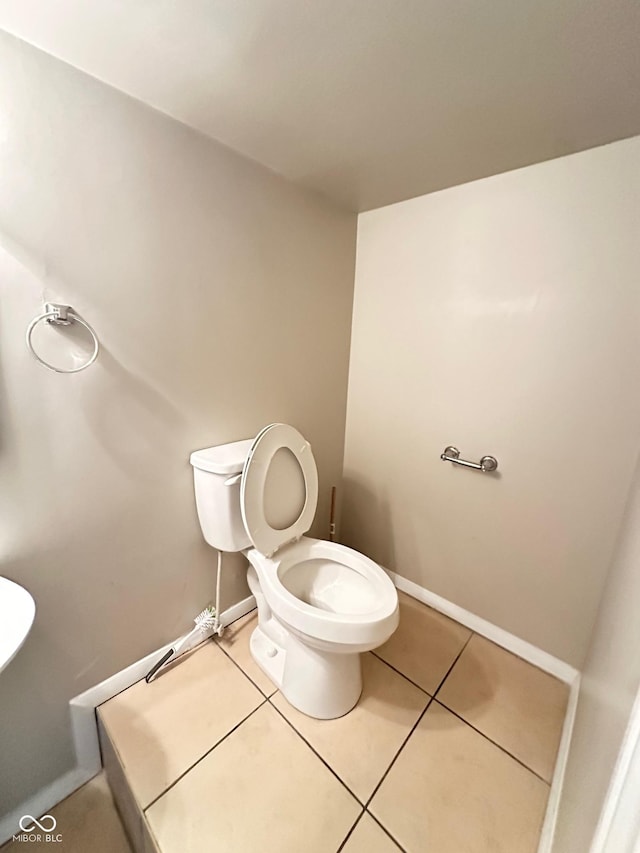 bathroom with tile patterned floors, toilet, and baseboards