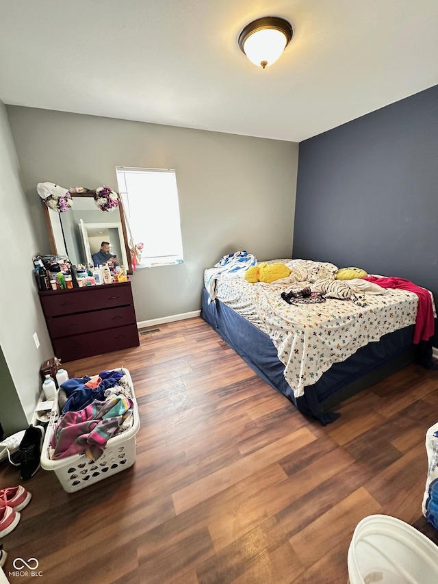 bedroom with baseboards and wood finished floors