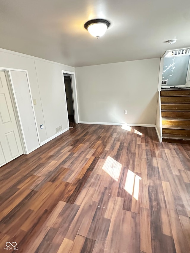 unfurnished bedroom with wood finished floors, visible vents, and baseboards