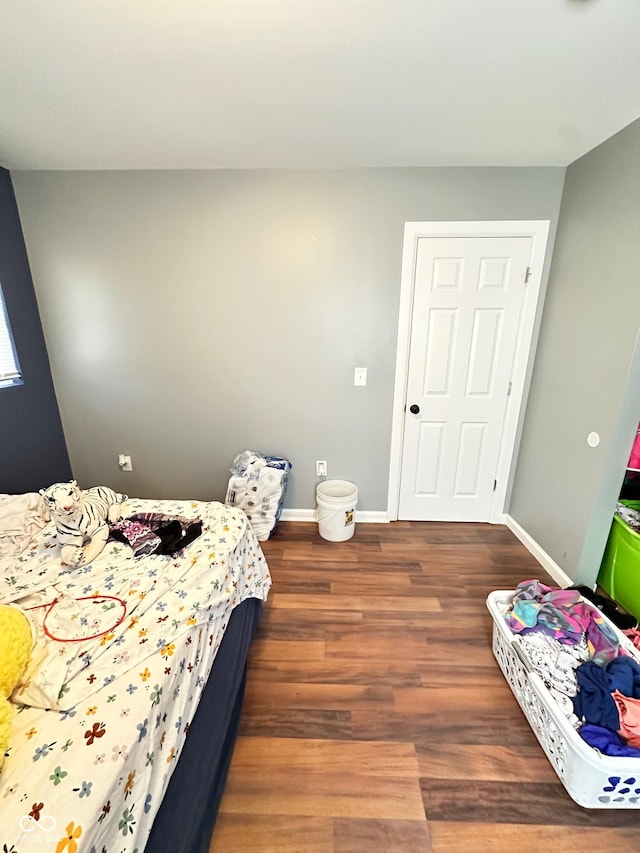 bedroom with dark wood-type flooring and baseboards