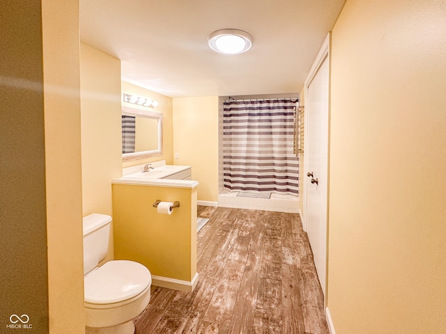 full bath with vanity, wood finished floors, baseboards, curtained shower, and toilet