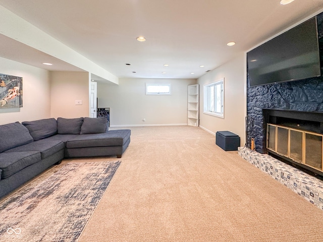 carpeted living room with recessed lighting, a large fireplace, and baseboards