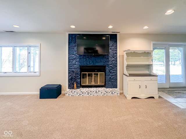 unfurnished living room featuring recessed lighting, carpet flooring, baseboards, and a high end fireplace