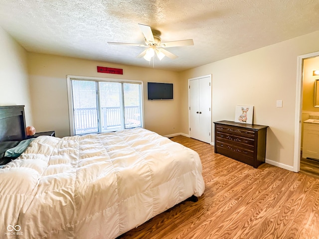 bedroom featuring baseboards, a textured ceiling, and light wood-style flooring