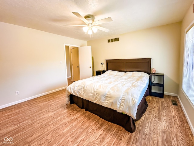 bedroom featuring visible vents, baseboards, and wood finished floors