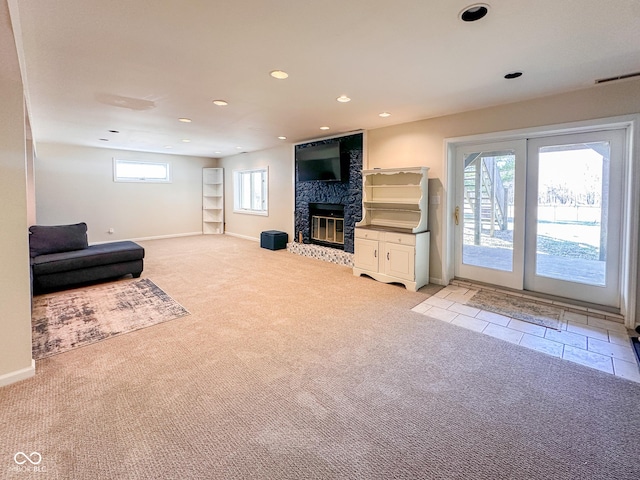 living room with plenty of natural light, light colored carpet, and a fireplace