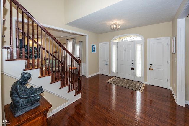 entrance foyer with baseboards, wood finished floors, and stairs