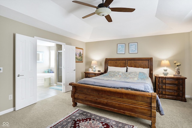 bedroom featuring ensuite bath, a tray ceiling, carpet, and baseboards