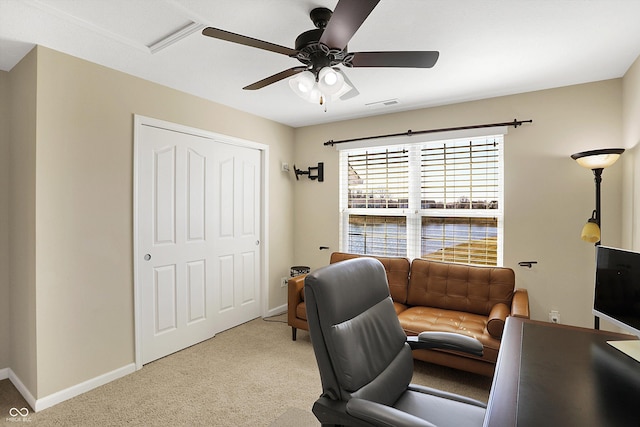 office space with visible vents, baseboards, light colored carpet, and ceiling fan