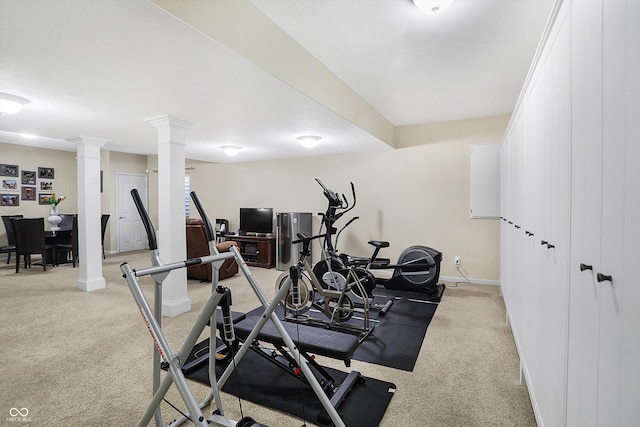 exercise room with light carpet, baseboards, and ornate columns