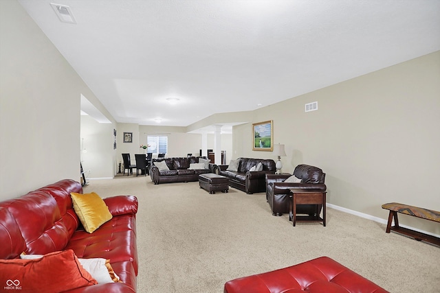 living room featuring visible vents, carpet floors, and decorative columns