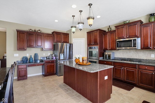 kitchen featuring dark stone counters, tasteful backsplash, appliances with stainless steel finishes, and a center island