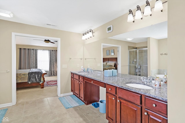 full bath with visible vents, a sink, connected bathroom, a shower stall, and double vanity