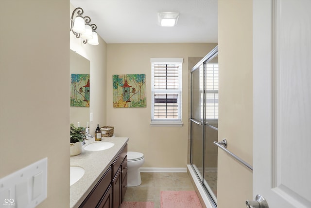 bathroom with toilet, a shower stall, tile patterned flooring, double vanity, and baseboards