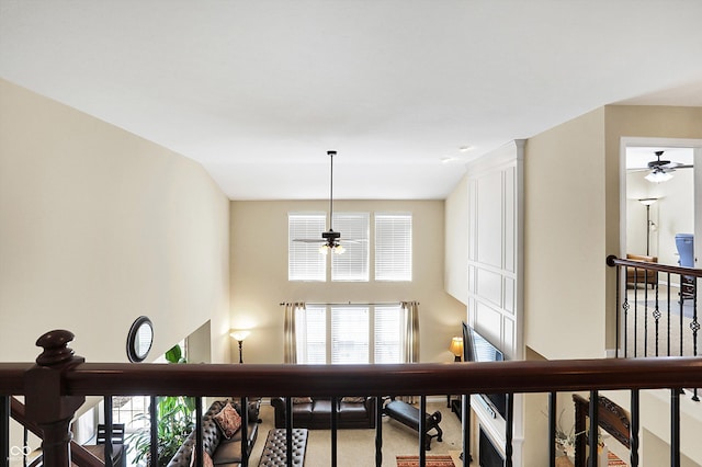 hall featuring an upstairs landing, carpet flooring, and a towering ceiling