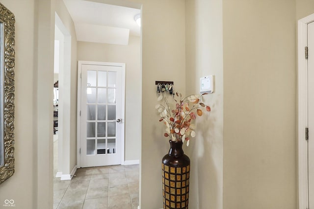 doorway to outside with light tile patterned floors and baseboards