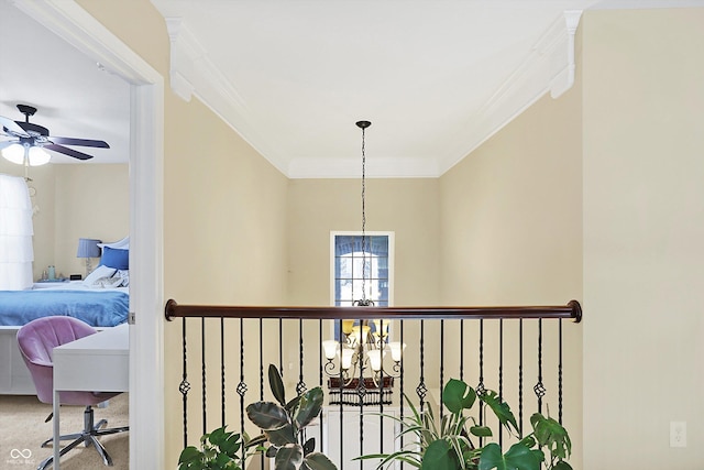 hallway with a notable chandelier, crown molding, and carpet