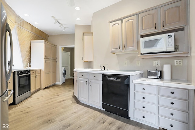 kitchen with white microwave, washer / dryer, electric range, freestanding refrigerator, and dishwasher