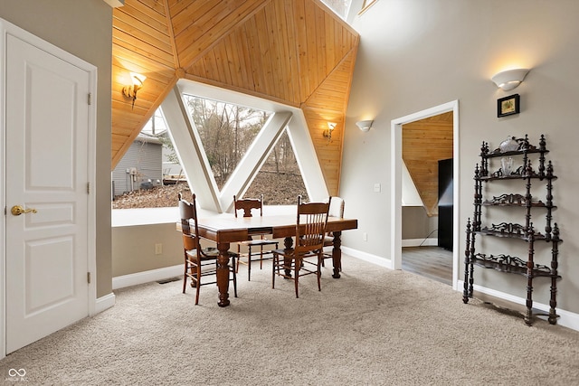 dining room featuring a skylight, a towering ceiling, baseboards, and carpet floors