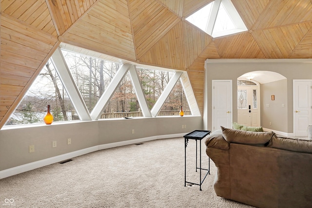 carpeted living area with plenty of natural light, high vaulted ceiling, and baseboards