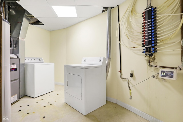 laundry room with laundry area, separate washer and dryer, and baseboards