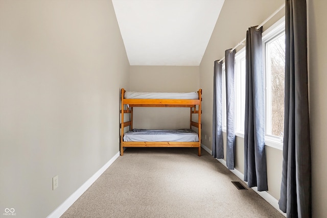 unfurnished bedroom featuring multiple windows, carpet, visible vents, and baseboards