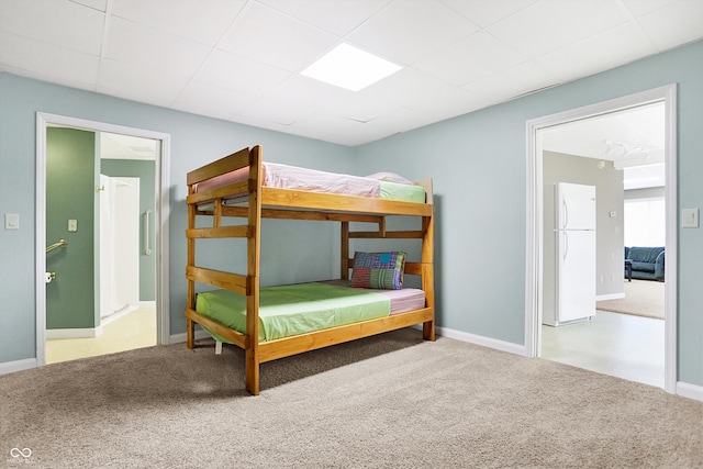 bedroom with baseboards, carpet flooring, and freestanding refrigerator