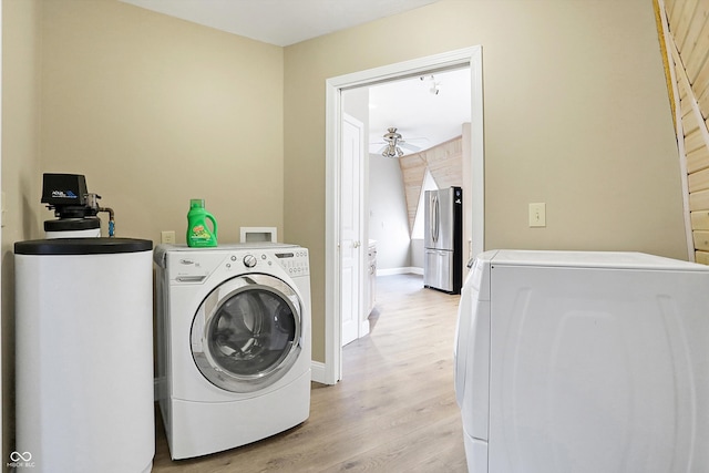 clothes washing area with light wood finished floors, ceiling fan, baseboards, laundry area, and separate washer and dryer