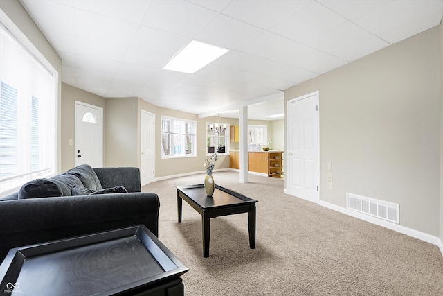 living area with carpet flooring, baseboards, visible vents, and a chandelier