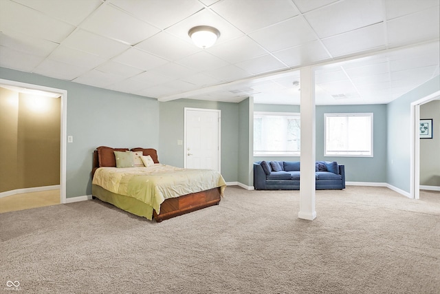 bedroom featuring carpet flooring, baseboards, and a drop ceiling