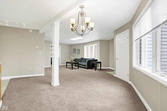 interior space featuring an inviting chandelier, track lighting, and baseboards