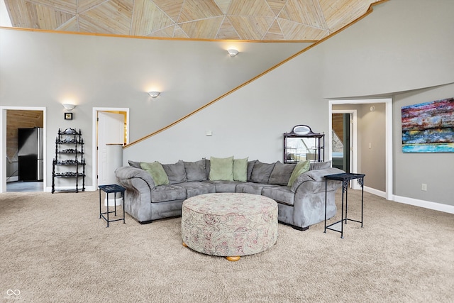 living area with carpet flooring, high vaulted ceiling, and baseboards