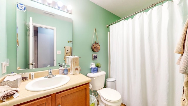 bathroom featuring vanity, a shower with shower curtain, toilet, and visible vents